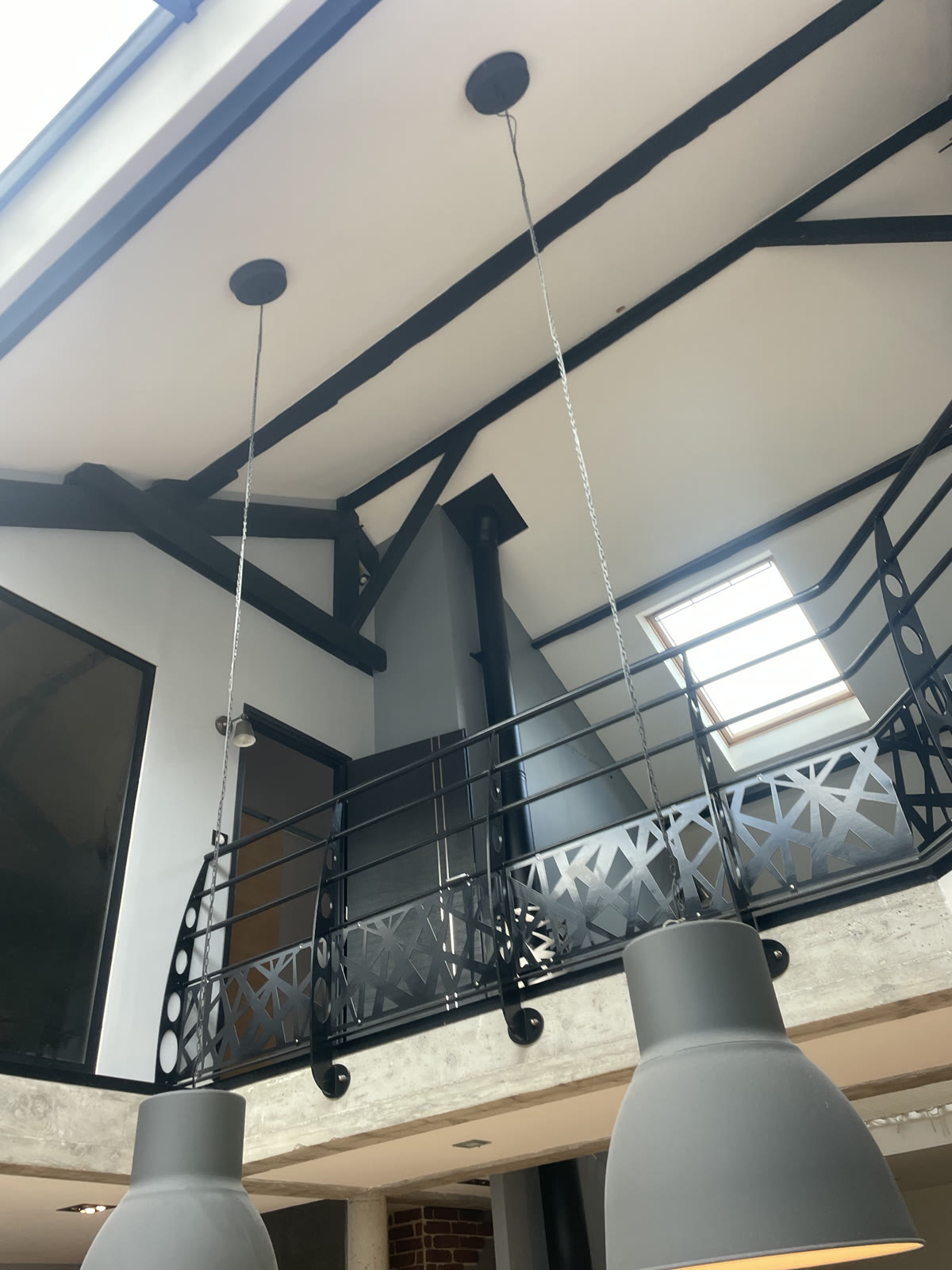 Volume intérieur avec mezzanine, charpente apparente et garde-corps