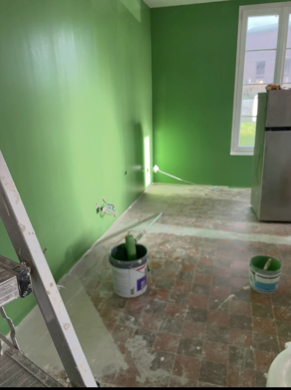 Pièce aux murs verts pendant les travaux de préparation et de peinture