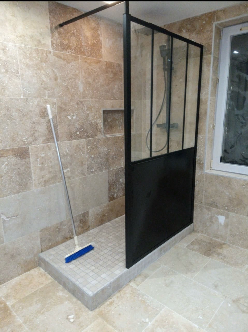 Espace de douche avec paroi vitrée à cadre noir et revêtement mural